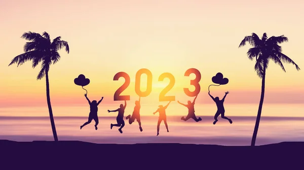 Silhouette friends jumping and holding number 2023 on sunset sky abstract background at tropical beach. Happy new year and holiday celebration concept. Vintage tone color style.