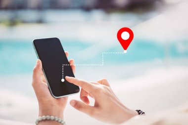 Tropikal günbatımı plaj soyut arka planında navigatör konumuna sahip akıllı telefon kullanan bir kadın. Teknoloji interneti ve seyahat macerası konsepti. Klasik ton filtre efekti renk biçimi.