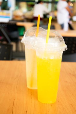 Kantindeki plastik bardakta portakal suyu ve greyfurt suyu..