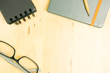Gözlükler ve üzerinde tahta defter olan kahverengi kalem. Üst görünüm, düz görünüm kavramı.