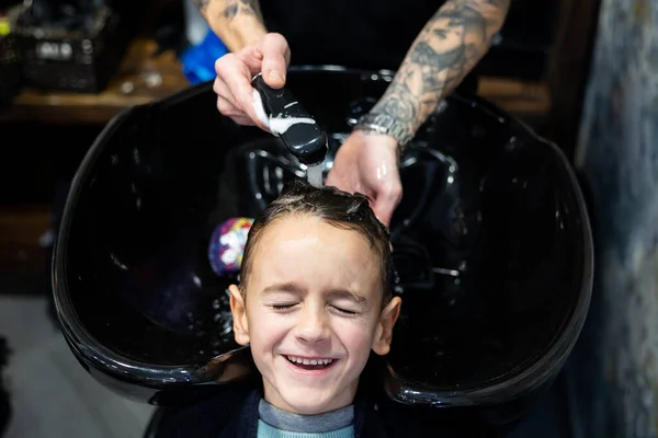Young Boy Smiling While Having His Hair Washed Hairdressing Salon lizenzfreie Stockfotos