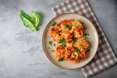 Biftek, karnabahar, peynirli, baharatlı, ev yapımı, açık gri bir masada, yakın çekim, üst görüş, seçici odak, insan yok.,