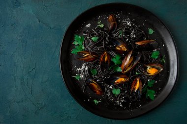 Spaghetti with black squid, black pasta, with boiled mussels, on a black plate, with parsley and parmesan cheese, close-up, selective focus, no people,