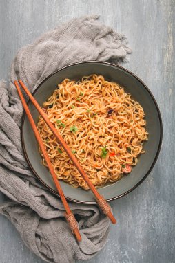 Instant noodles, in a bowl, on a gray table, top view, no people,