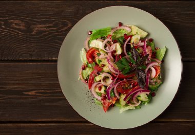 Georgian vegetable salad, tomatoes with cucumbers, red onion, walnut, pomegranate seeds, top view, no people,