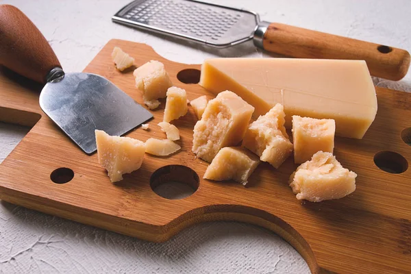 stock image Hard cheese, parmesan, on a cutting board, cheese knife, grater, top view, no people,