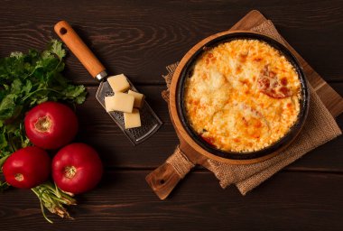 Baked tomatoes with Suluguni cheese , Ketsi in a clay pan , Georgian dish, homemade, top view, on a wooden table, no people,