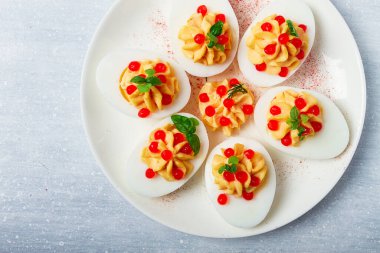 Doldurulmuş yumurta, kırmızı havyar, mikro yeşillik, aperatif, beyaz tabakta, üst manzara, yakın çekim, insan yok.,