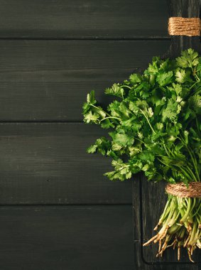 Bir grup taze Cilantro, gri ahşap bir masada, yakın plan, üst manzara, insan yok..