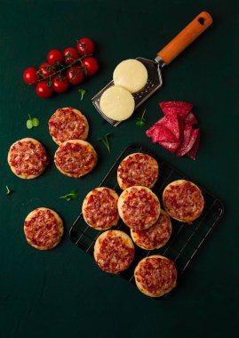 Mini pizzas, salami with mozzarella cheese, on the table, top view, no people,