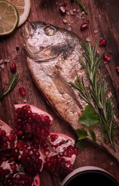 Kızarmış dorado balığı, baharat ve otlarla ahşap bir tahtanın üzerinde, nar sosu, yakın plan, insan yok.,