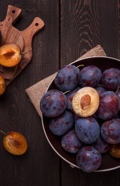 Mavi erik, ahşap bir masanın üstünde, üst manzara, yakın plan, insan yok.,