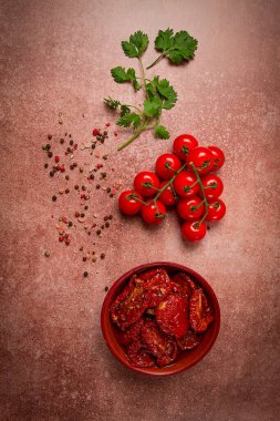 Kahverengi arka planda, üst manzaralı bir kasede kurutulmuş domatesler.,