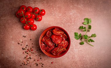 Kahverengi arka planda, üst manzaralı bir kasede kurutulmuş domatesler.,