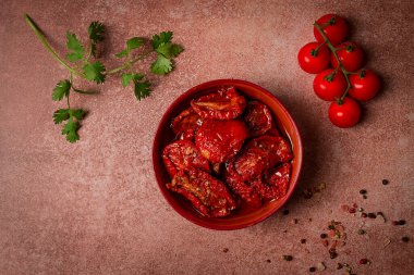 Kahverengi arka planda, üst manzaralı bir kasede kurutulmuş domatesler.,