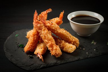 Tempura 'da karides, bol yağda kızartılmış, siyah tahtada, soya soslu, yatay, insan yok.,