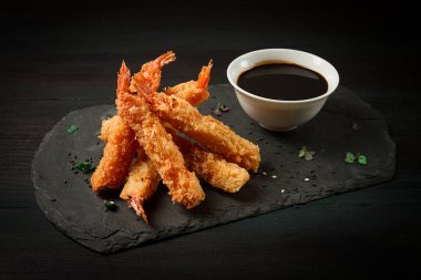Tempura 'da karides, bol yağda kızartılmış, siyah tahtada, soya soslu, yatay, insan yok.,