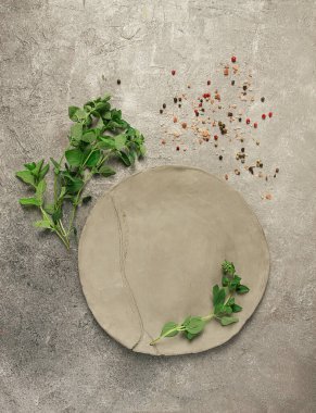 Gri kil tabak, el yapımı, fesleğen dalları, üst görünümü, yemek arkaplanı, menü için yiyecek duvar kağıdı.,