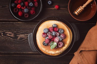 Kahvaltı, böğürtlenli ve ballı krep, üst manzara, ev yapımı, insan yok, ahşap bir arka planda.,