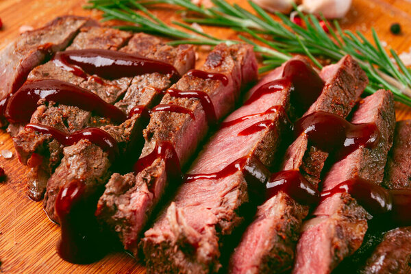 Fresh fried rib eye steak, on a chopping board, with barbecue sauce, homemade, close-up,