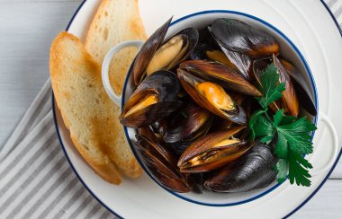 Fresh, Boiled mussels, Black Sea, with white bread, on a white wooden table, no people,