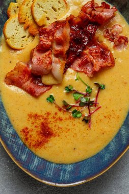 Balkabağı kreması çorbası, köri, kızarmış pastırma, bruschetta cipsi, mikro-yeşillikler, üst manzara, insan yok.,