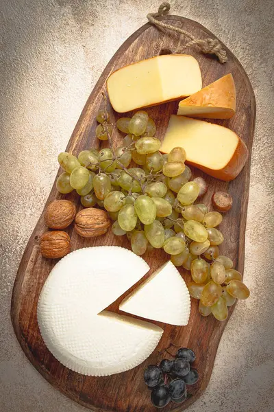 Georgian cheese, Imeretian and smoked suluguni, grapes, nuts, on a cutting board, Georgian cuisine, no people,