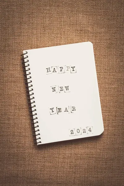 Printed text, happy New Year 2024, in notepad, typewritten text, top view, glider,