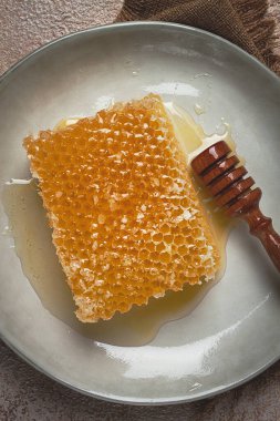 Bal peteği, ahşap bir kaşıkla, tabakta, insan yok.,