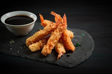 Tempura 'da karides, bol yağda kızartılmış, siyah tahtada, soya soslu, yatay, insan yok.,