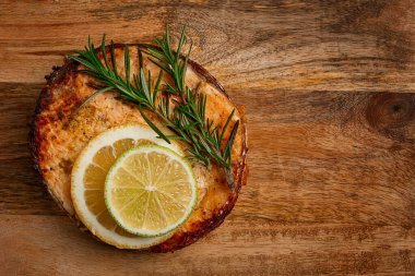 Somon bifteği, kızarmış, kesme tahtasının üstünde, üst manzara, biberiye, limon ve limon, ev yapımı, tek porsiyon, insan yok.,