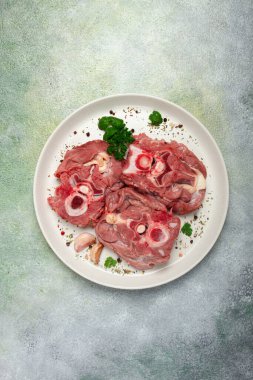 Çiğ biftek, kemikte dana boynu, taze et, beyaz tabakta, üst manzara, insan yok.,