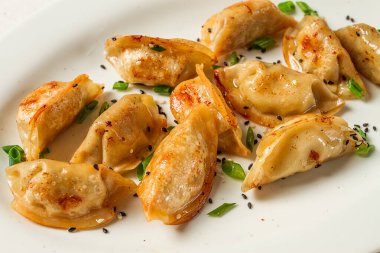 Japon usulü kızarmış gyoza köftesi, domuz eti, susam tohumu, yeşil soğan.,