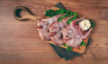 Kesme tahtasında çiğ bıldırcın eti, baharatlar ve otlarla, üst görünüm.,