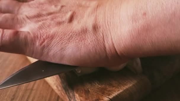 ナイフでニンニクの球根を切る チョッピングボードで 木のテーブル ナイフ 素朴なスタイル モバイルビデオ 人なし — ストック動画