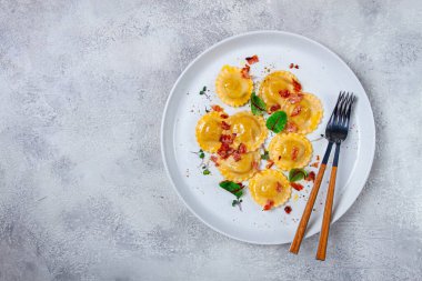 Taze ravioli, tereyağlı, baharatlı ve otlu, kızarmış pastırmalı, masada, üst tarafta, arka planda, insan yok.,