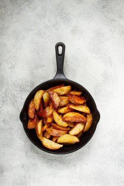 Kızarmış patates dilimleri, dökme demir bir tavada, ev yapımı, insan yok.,