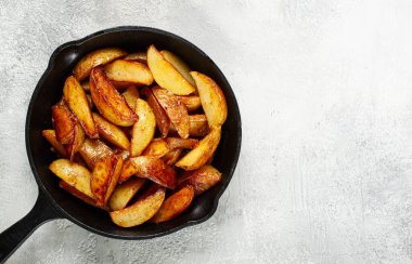 Kızarmış patates dilimleri, dökme demir bir tavada, ev yapımı, insan yok.,