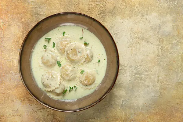 stock image ravioli in cream sauce, spices and herbs, top view, no people,