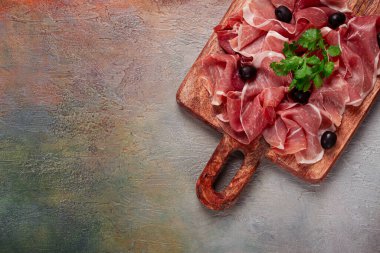 Kesme tahtasında dilimlenmiş jambon, zeytin ve otlarla, atıştırmalık, kahvaltı, insan yok.,