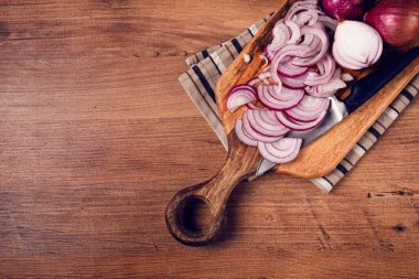 Kesme tahtasında dilimlenmiş kırmızı soğan, bir bıçakla, İspanyol soğanı, çiğ soğan, yakın plan, üst görünüm,