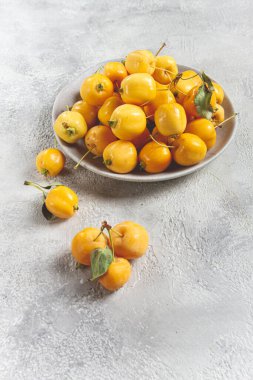Sarı küçük elmalar, Çin çeşitleri, gri bir tabakta, üst manzara, insan yok.,