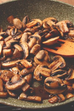 Kızarmış mantarlar tavada, ahşap çatalla, ev yapımı, insan yok.,