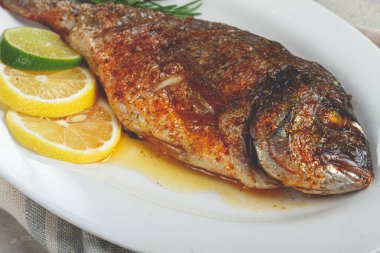 fırında Dorado balığı, fırında, baharat ve otlarla kızartılmış dorado, beyaz bir tabakta, üst manzara, ev yapımı, insan yok.,