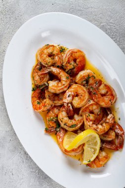 Kızarmış kaplan karidesi, jumbo, sarımsak soslu, tereyağlı, otlu, beyaz tabakta, ev yapımı, insan yok.,