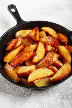 Kızarmış patates dilimleri, dökme demir bir tavada, ev yapımı, insan yok.,