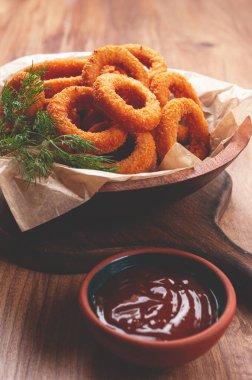 Kızarmış soğan halkaları, aperatif, domates soslu, ahşap bir masada, insan yok, en sevdiği yemek.,