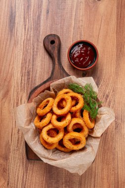 Kızarmış soğan halkaları, aperatif, domates soslu, ahşap bir masada, insan yok, en sevdiği yemek.,