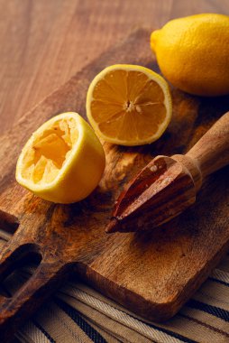 Limonlar ve ahşap manuel narenciye sıkacağı, kesim tahtasında, yakın plan, insan yok.,