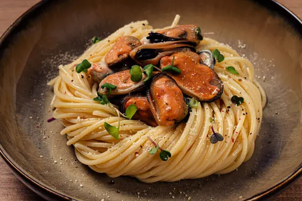 stock image spaghetti with mussels, without shell, pasta with peeled mussels, in carbonara sauce, micro-greens, homemade, no people,